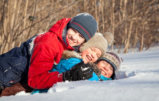 Happy,Children,In,Winterwear,Laughing,While,Playing,In,Snowdrift,Outside