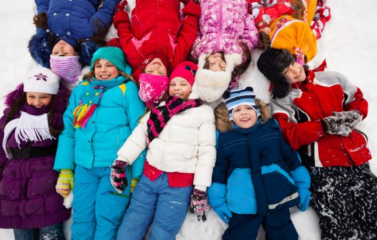 Large,Group,Of,Kids,Laying,In,Snow,Together,In,One